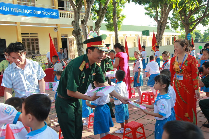Đại diện lãnh đạo Trung đoàn 764 - Bộ Chỉ huy quân sự tỉnh trao quà cho các em học sinh. Ảnh: Thiên Thiên 