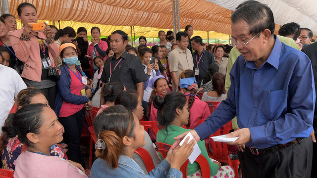 Thủ tướng Hun Sen trong lần xuống tặng tiền cho người dân nghèo ở vùng ven thủ đô Phnom Penh hôm 30-8 - Ảnh: AFP