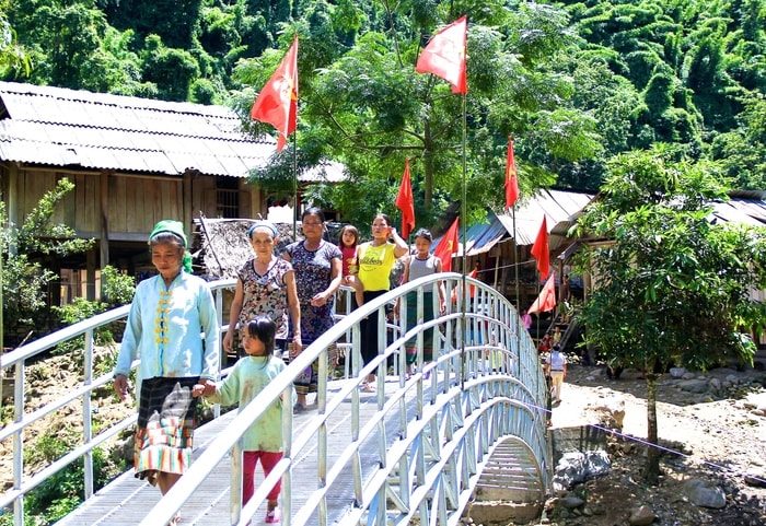 Người dân bản Huồi Pủng hân hoan đi lại trên cây cầu mới. Ảnh: Mỹ Nga