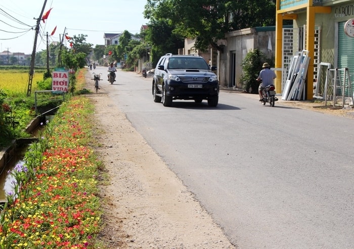 Từ cổng chào vào đến trụ sở làm việc của xã, những luống hoa tươi nở rực dọc bên đường. Ảnh: Việt Hùng