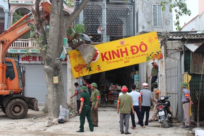 Nhà thầu đã huy động máy móc hỗ trợ tháo dỡ nhà cửa, chặt cây cối. Ảnh: Lê Nhung