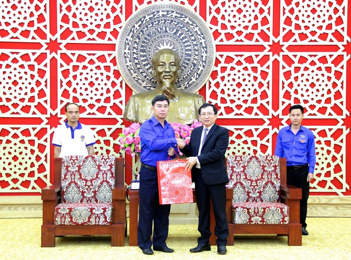 Phó Chủ tịch UBND tỉnh Đinh Viết Hồng thay mặt Tỉnh uỷ, UBND tỉnh Nghệ An trao tặng món quà cho Đoàn TNDCCM Lào. Ảnh: Mỹ Nga