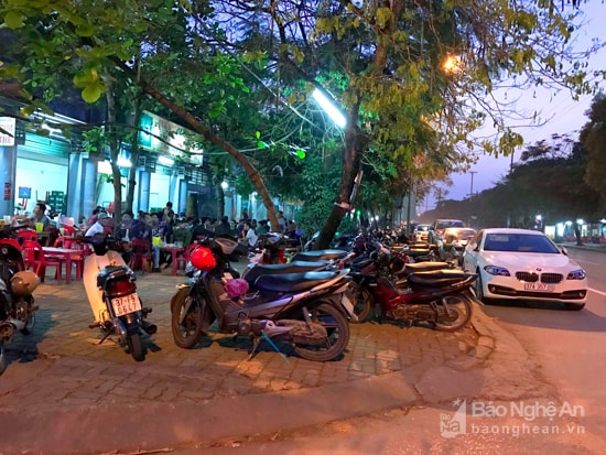 Đường Phan Đăng Lưu là một trong số tuyến đường diễn ra tình trạng lấn chiếm vỉa hè nhiều nhất tại TP.Vinh. Ở đây tập trung rất nhiều quá bia nên chiều và tối có rất nhiều khách vào ăn uống. Ô tô, xe máy, bàn ghế dựng tràn lan trên vỉa hè, thậm chí tràn xuống dưới lòng đường. Ảnh: Quang An