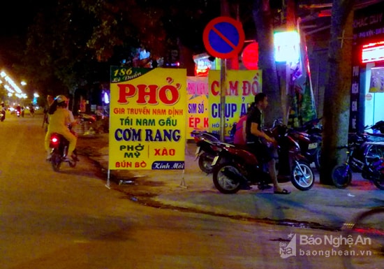 Biển quảng cáo bày biện công khai trên vỉa hè đường Lê Duẩn. Ảnh: Quang An