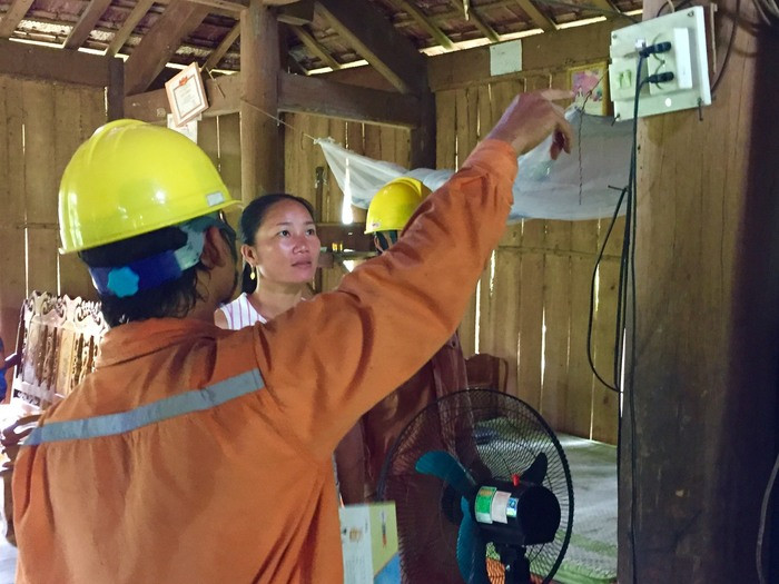 Công nhân Điện lực Quỳ Châu hướng dẫn người dân cách sử dụng điện an toàn trong mùa mưa bão. Ảnh: Hà Thảo