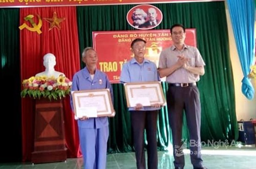 Đồng chí Đàm Hữu Hồng - Phó Bí thư Huyện ủy Tân  Kỳ trao tặng Huy hiệu 50  tuổi Đảng cho 2 đảng viên. Ảnh: Phương Hảo
