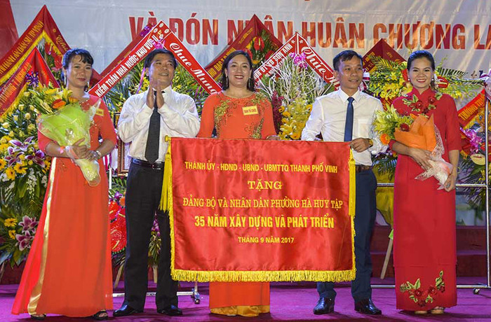 Thành phố Vinh trao bức trướng chúc mừng Đảng bộ và nhân dân phường Hà Huy Tập. Ảnh: Sỹ Minh