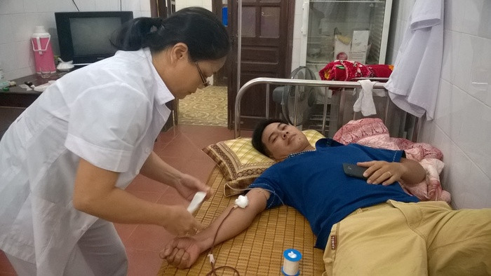 Cán bộ Trung tâm Y tế Tân Kỳ đang hiến máu cho bệnh nhân. Ảnh: Hương Trà