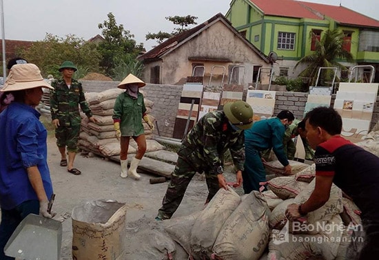 Giúp bà con Quỳnh Hậu thu dọn vật liệu, xi măng vào kho, nhà trước khi bão đến