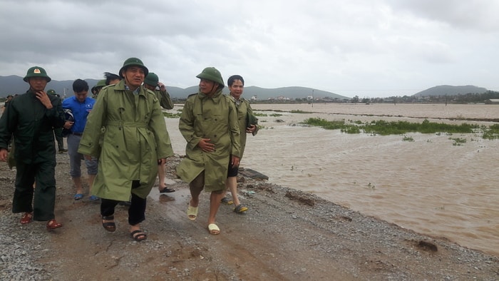 Bí thư Tỉnh uỷ Nguyễn Đắc Vinh kiểm tra khu vực nuôi tôm của người dân thị xã Hoàng Mai bị ngập nước. Ảnh: Thành Duy