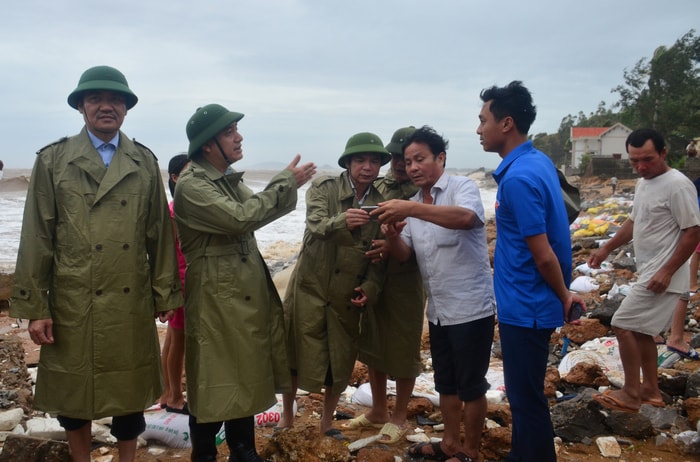 Bí thư Tỉnh uỷ trao đổi với người dân phường Quỳnh Phương về tình hình sạt lở do sóng biển. Ảnh: Thành Duy