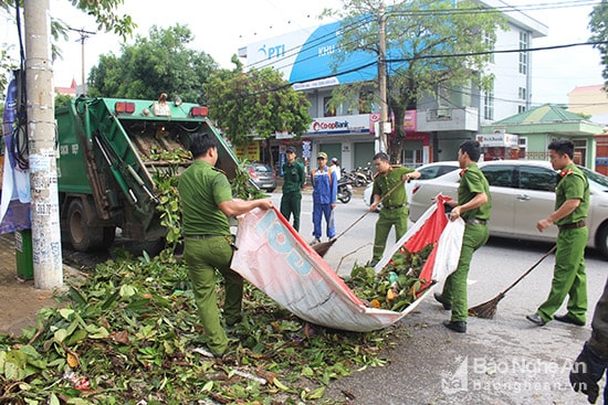 Lực lượng công an Thành phố Vinh cùng tham gia xử lý rác. Ảnh: Vương Bằng