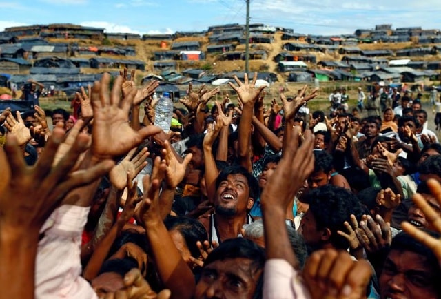 Những người tị nạn Rohingya vươn tay để nhận viện trợ do các tổ chức địa phương phân phối tại trại tị nạn tạm thời Balukhali ở Cox's Bazar, Bangladesh.