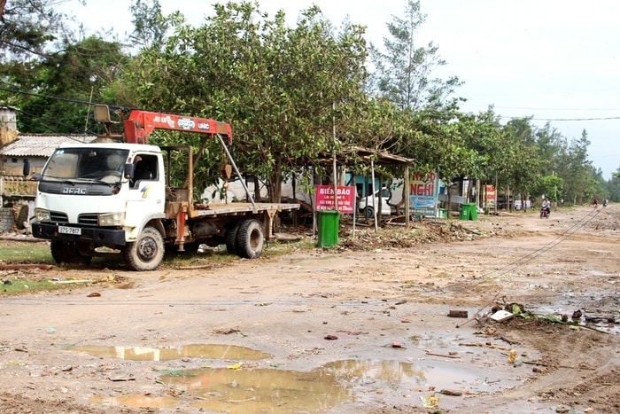 Ông Tô Duy Hiện - Chủ tịch UBND xã Quỳnh Nghĩa cho biết, hiện nay địa phương đang chỉ đạo lực lượng dân quân tự vệ, công an, thuê 2 máy múc xuống hỗ trợ người dân khắc phục hậu quả sau bão; trước hết là dọn dẹp các công trình trên đường để người dân đi lại thuận lợi, sau đó khắc phục hậu quả bên trong nhà hàng. Ảnh: Việt Hùng