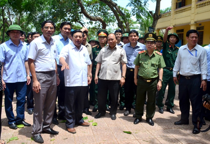 Thủ tướng Nguyễn Xuân Phúc nghe báo cáo tình hình thiệt hại do bão số 10 gây ra tại Trưởng Tiểu học Nghi Hải, thị xã Cửa Lò. Ảnh: Thành Duy