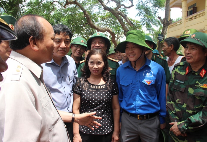 Thủ tướng trao đổi với các lực lượng đang giúp Trường Tiểu học Nghi Hải khắc phục hậu quả bão số 10. Ảnh: Hoài Thu