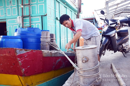 Ngư dân Nguyễn Hồ Trung thả dây neo cho thuyền rời bến. Ảnh: Xuân Hoàng