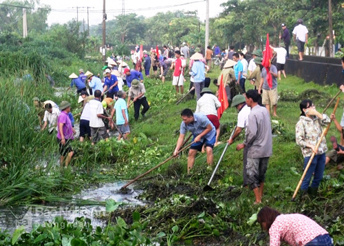 Người dân xã Hưng Đông TP Vinh tham gia làm thủy lợi, khơi thông dòng chảy, vệ sinh môi trường sau bão số 10. Ảnh: Hồng Quang