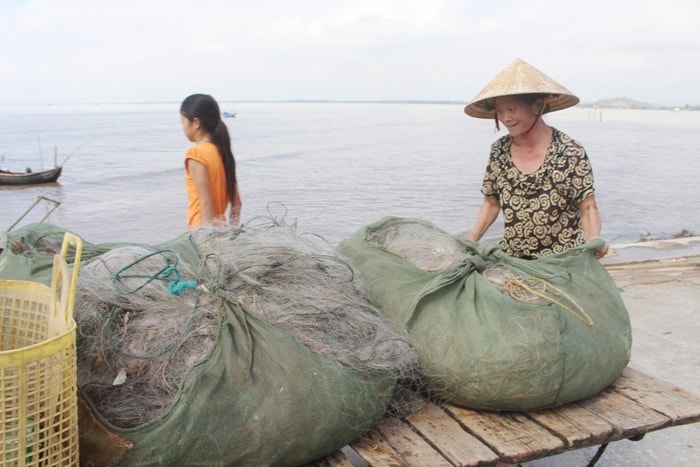 Chị Nguyễn Thị Minh ở xã Quỳnh Lon ra bến vận chuyển hải sản về; chuyến đánh bắt sau bão gia đình thu nhập hơn 3 triệu đồng/buổi. Ảnh: Việt Hùng