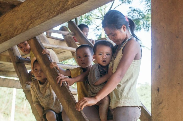 Những đứa trẻ ở bản Đan Lai chơi bên cầu thang nhà sàn, bên hàng rào ven bản với khuôn mặt nhọ nhem. Chúng ngơ ngác nhìn 