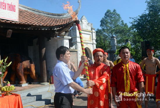 Ngọn lửa được Chủ tịch UBND thành phố Vinh rước từ Thượng điện Đền thờ Hoàng Đế Quang Trung trao cho các nghệ nhân đúc súng thần công. Ảnh: Thanh Sơn