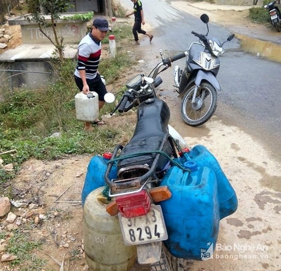 Một số nơi người dân còn dùng xe máy đi xa để được chở nhiều can nước. Ảnh: Đào Thọ