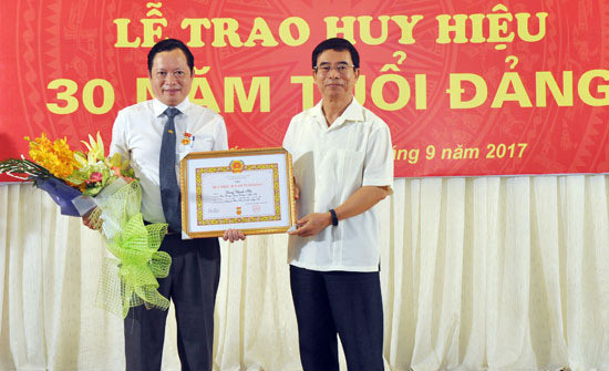 Đồng chí Nguyễn Hữu Lậm trao tặng Huy hiệu 30 năm tuổi Đảng cho đồng chí Lương Thanh Hải - Trưởng Ban Dân tộc tỉnh. Ảnh: Công Kiên
