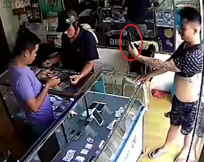 Thanh niên dùng chiếc iPhone chụp ảnh trước khi cầm điện thoại bỏ chạy. Ảnh cắt từ clip.