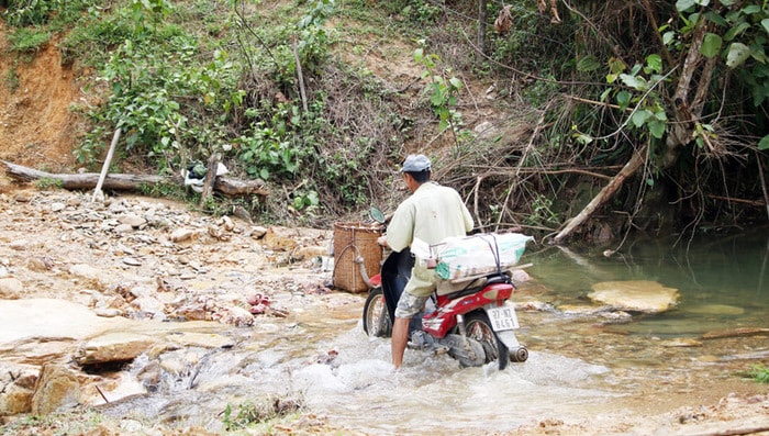 Sau bão, cầu bị trôi, người dân chỉ còn cách phóng xe qua suối như thế này. Ảnh: Hữu Vi