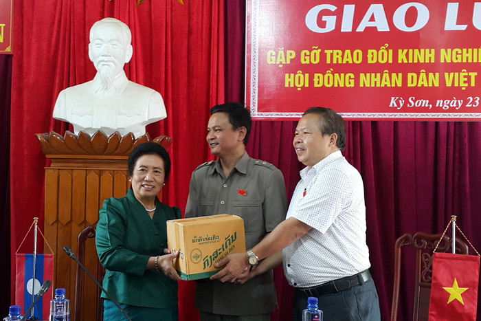 Bà Bựa Phăn Lỳ Ca Da - Chủ tịch Ủy ban Dân tộc Quốc hội Lào tặng quà cho huyện Kỳ Sơn. Ảnh: Nguyễn Anh Tuấn