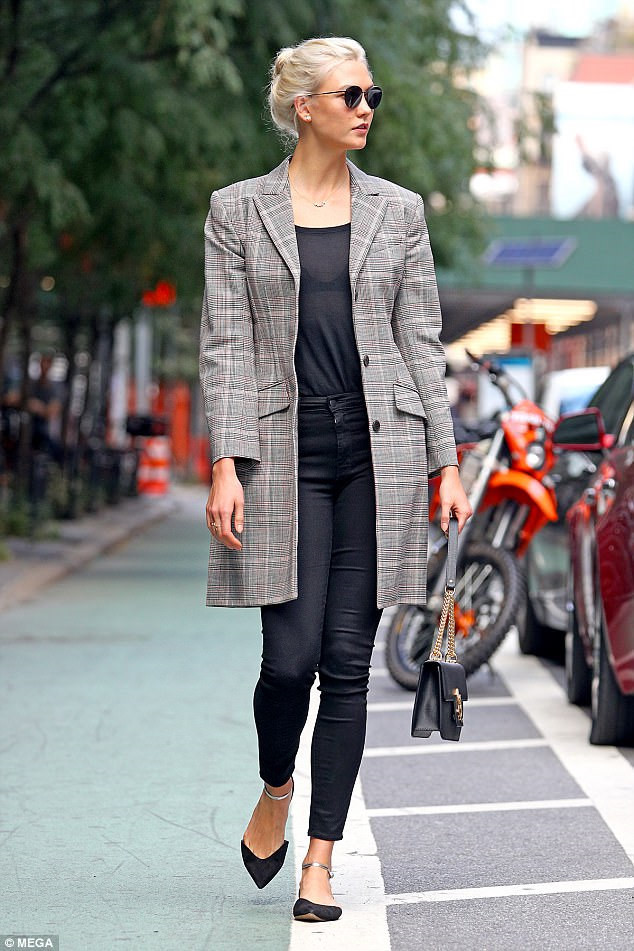 Karlie Kloss với trench coat kẻ caro nhỏ tạo điểm nhấn cho set đồ đen đơn giản.