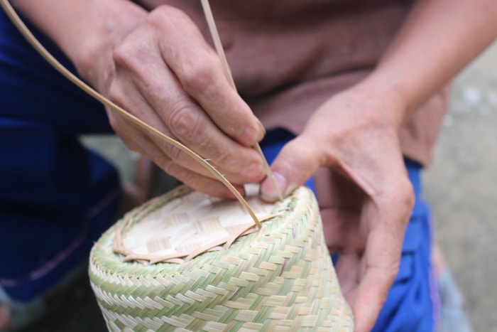 Lắp đáy ép xong sẽ tiến hành khâu thân đáy vào thân ép. Vật liệu dùng để khâu là mây. Ảnh: Đình Tuân