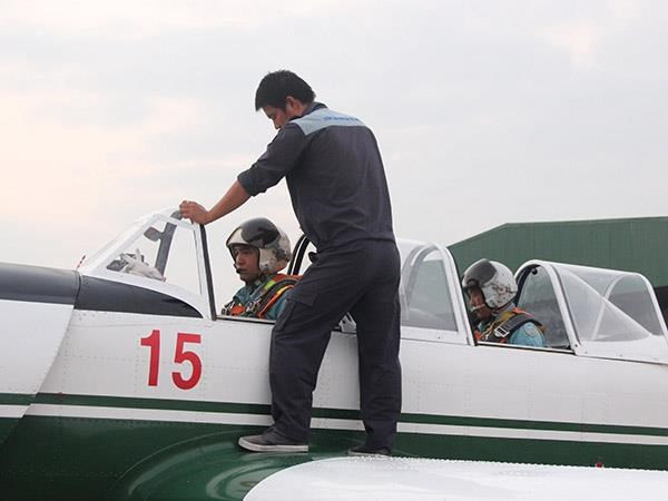 Kỹ thuật viên giúp phi công chuẩn bị buồng lái.