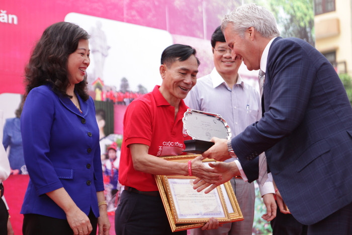 Ông Hà Văn Phúc nhận Bằng khen của Quỹ Bảo trợ trẻ em Việt Nam và Kỷ niệm chương từ Tổng Giám đốc AIA Việt Nam. Ảnh: Lương Mai