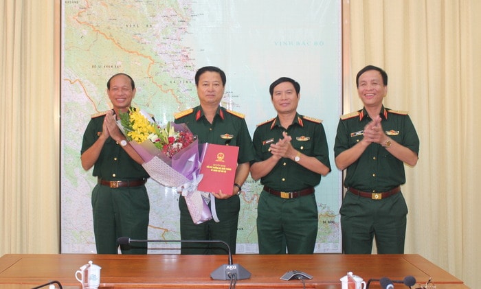 Trung tướng Nguyễn Tân Cương - Tư lệnh Quân khu trao Quyết định Chủ nhiệm Chính trị Quân khu cho Đại tá Trần Minh Thanh và Thủ trưởng Bộ Tư lệnh Quân khu tặng hoa chúc mừng. Ảnh: Phạm An