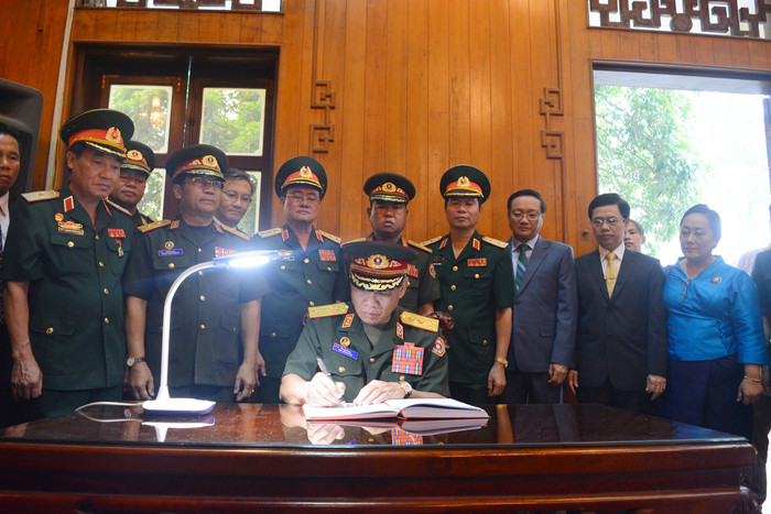 Thượng tướng Vị-lay Lạ-khăm-phong - Thứ trưởng Bộ Quốc phòng Lào đại diện đoàn đại biểu ghi cảm tưởng vào Sổ vàng lưu niệm. Ảnh: T,G