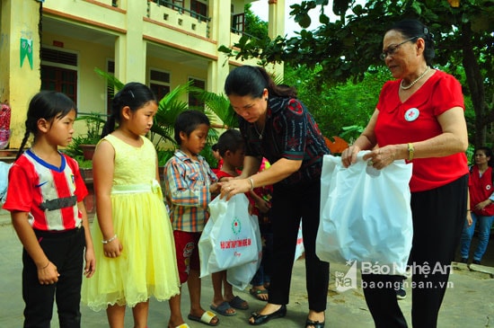 Bà Kha Thị Tím - Phó Chủ tịch UBND huyện Con Cuông trao quà áo ấm đồng phục cho các em học sinh Tiểu học Cam Lâm. Ảnh: Nguyễn Hải