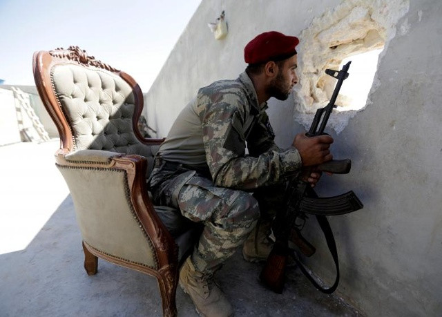 Một chiến binh của Quân đội Tự do Syria (Al-Hamza Brigade) được nhìn thấy nhìn ra thị trấn Hazwan ở Aleppo, Syria.