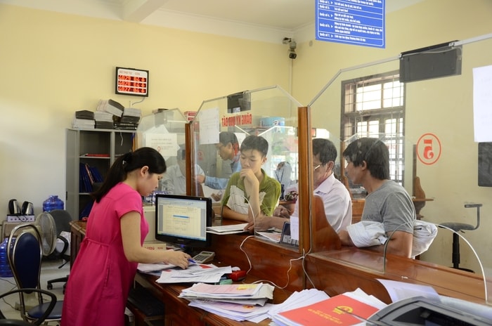 Giải quyết thủ tục hành chính cho người dân tại Trung tâm một cửa UBND huyện Nghi Lộc. Ảnh: Thanh Lê