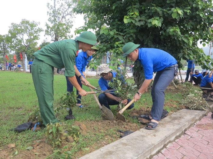 Đoàn viên thanh niên Đô Lương và Chiến sỹ Tiểu đoàn 14-Sư 324 cùng phối hợp trồng hoa. Ảnh: Ngọc Phương