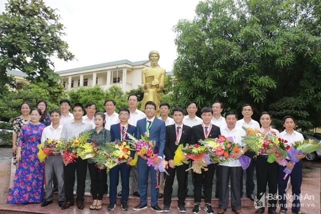 Các đồng chí lãnh đạo tỉnh và Sở Giáo dục và Đào tạo tặng hoa và chụp ảnh lưu niệm với các giáo viên và học sinh đạt giải. Ảnh: Mỹ Hà