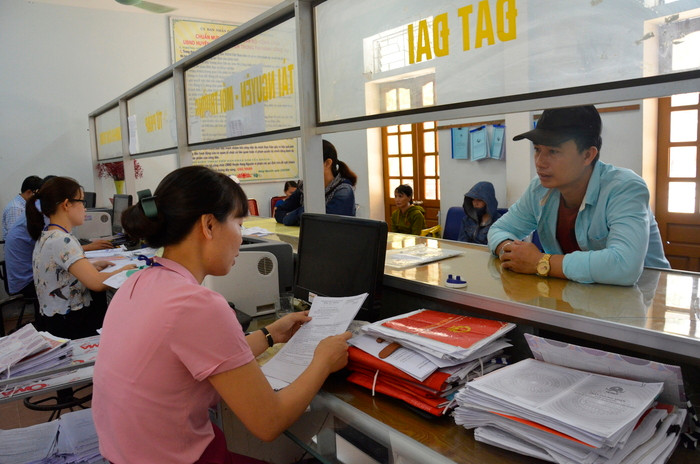 Giải quyết TTHC cho người dân tại Bộ phận một cửa UBND huyện Hưng Nguyên. Ảnh: Lê Thanh