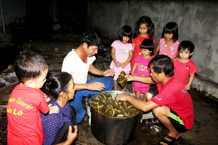 Đêm nấu bánh cũng là đêm hội của người lớn và trẻ em. Hàng trăm chiếc bánh được sắp vào những chiếc nồi lớn và nấu ngay giữa sân nhà văn hóa. Người giục lửa, người thay nước, rửa bánh được phân công rất rõ ràng. Ảnh: Huy Thư