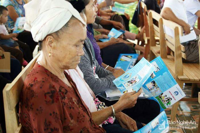 Bà con dân tộc thiểu số huyện Con Cuông tìm hiểu chính sách dân số qua tờ rơi. Ảnh: Mỹ Hà
