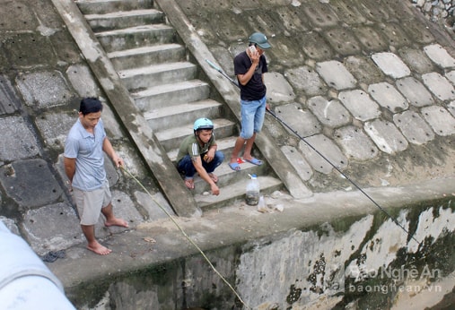 Nhiều người thậm chí không đứng trên cầu mà bước xuống sát lòng kênh để thỏa mãn thú vui câu cá. Ảnh: Quang An