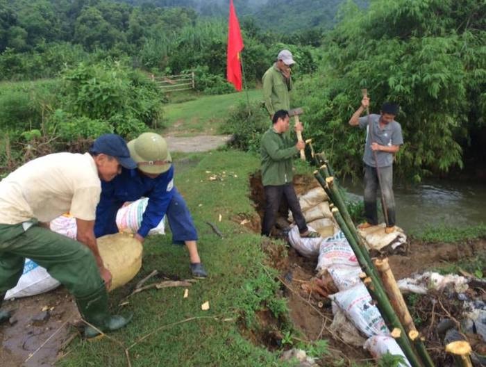 Nông dân bản Tát, xã Chi Khê đắp bờ kè chống sạt lở bên khe suối. Ảnh: Tường Vi