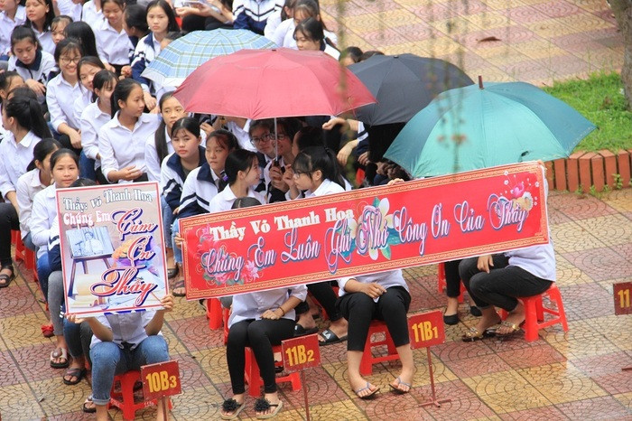 Buổi lễ chia tay chưa kết thúc thì trời đổ mưa, dù vậy, hàng ngàn học sinh vẫn nán lại dưới mưa để buổi chia tay người thầy hiệu trưởng của mình được trọn vẹn. Ảnh: Thiên Thiên
