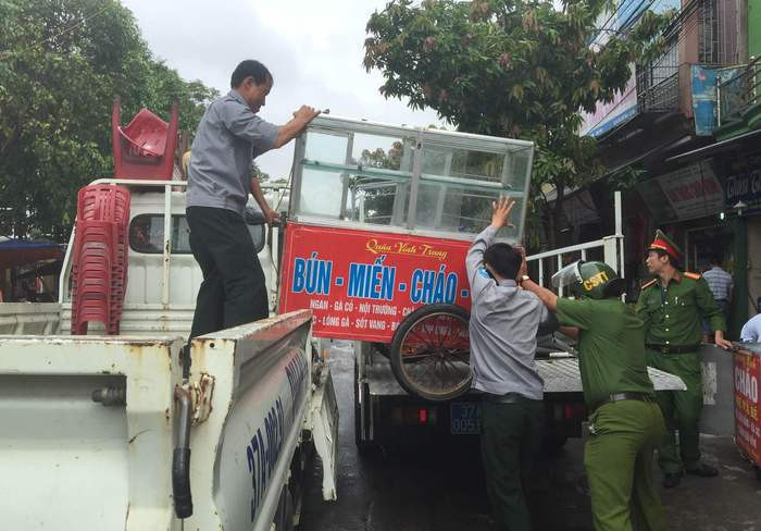 Đội tạm giữ biển quảng cáo, bàn ghế của người dân để xử lý theo quy định. Ảnh: Võ Huyền