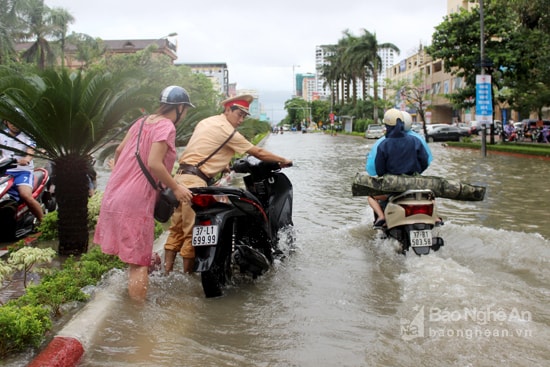 Cảnh sát giao thông Vinh giúp dân đẩy xe trong lụt.