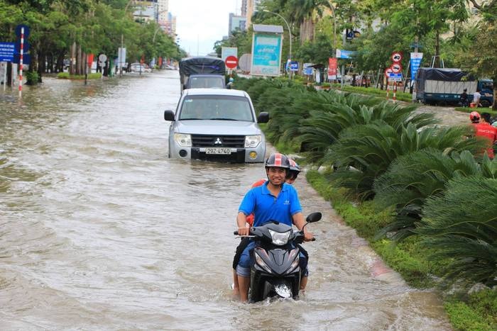 Gần trưa nhưng đường Quang Trung - tuyến đường chính của Thành phố Vinh vẫn ngập sâu trong nước. Ảnh: Mỹ Hà
